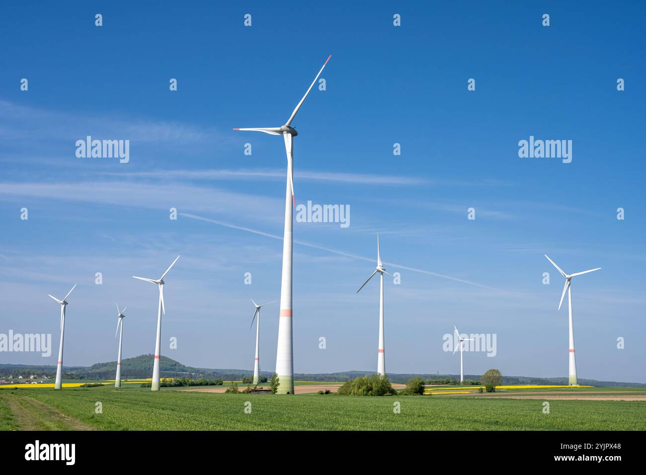 Moderne Windenergieanlagen mit grünen landwirtschaftlichen Feldern in Deutschland Stockfoto