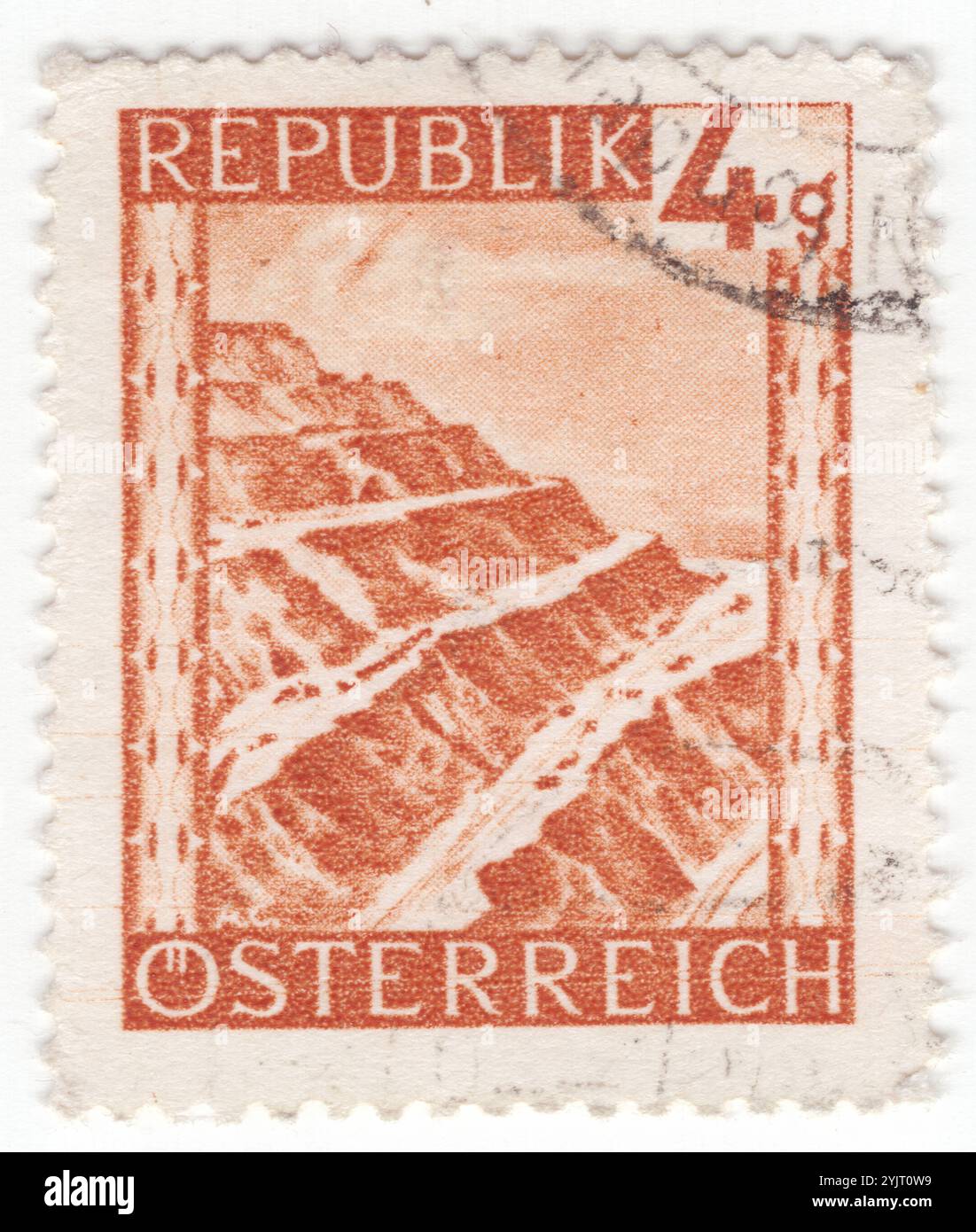 ÖSTERREICH - 1946. Januar 02: 4 groschen tieforangen Briefmarken zur Entnahme von Erzberg, Eisenerz. Sehenswürdigkeiten und malerische Orte in Österreich. Eisenerz ist ein Marktplatz und alte Bergbaustadt in der Steiermark. Er liegt im tiefen Erzbachtal, im Osten vom Pfaffenstein, im Westen vom Kaiserschild und im Süden vom Erzberg dominiert. Sie verfügt über eine mittelalterliche Kirchenburg, ein gotisches Gebäude, das im 13. Jahrhundert von Rudolph von Habsburg gegründet und im 16. Jahrhundert wieder aufgebaut wurde Stockfoto