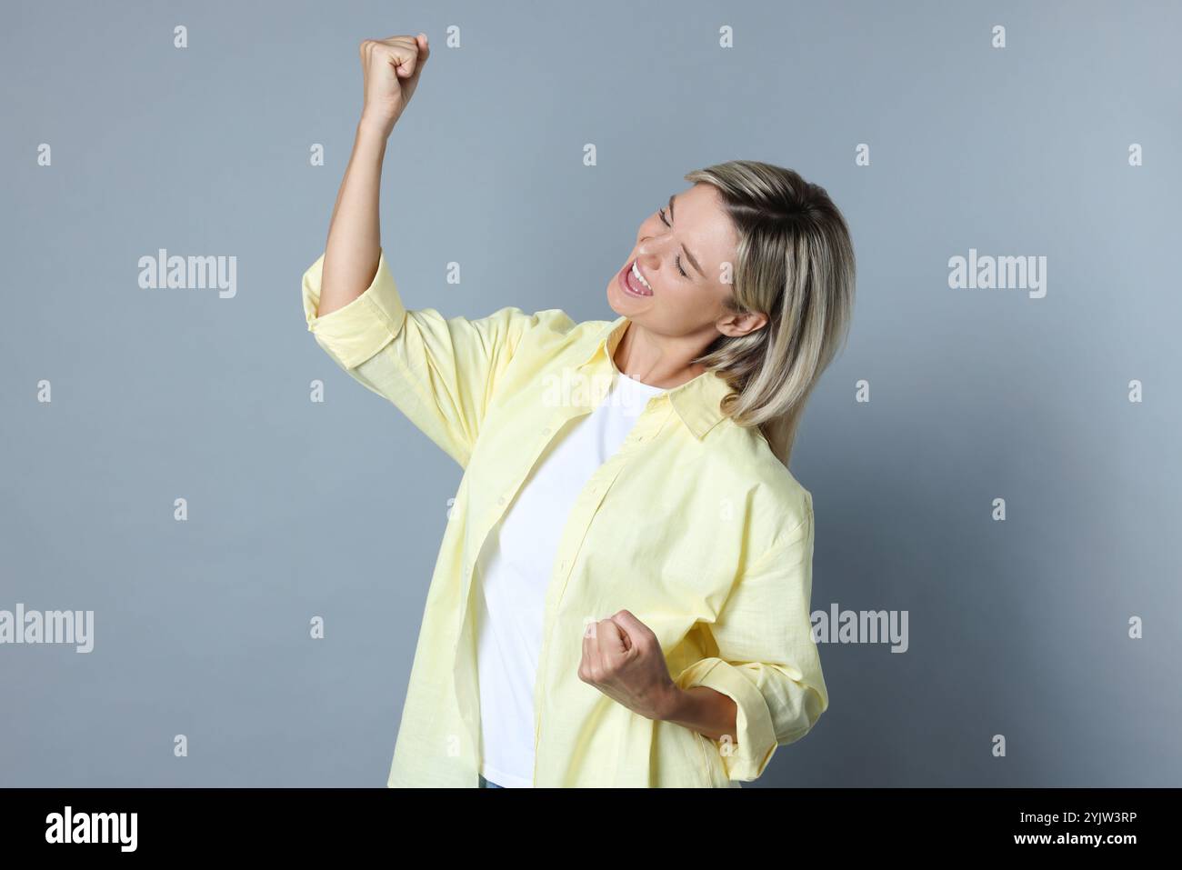 Porträt des glücklichen Gewinners auf grauem Hintergrund Stockfoto