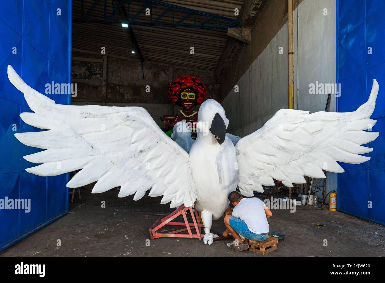 Ein kolumbianischer Handwerker arbeitet an einer Papier-mâché-Skulptur für einen allegorischen Wagen außerhalb der Karnevalswerkstatt in Barranquilla, Kolumbien. Stockfoto