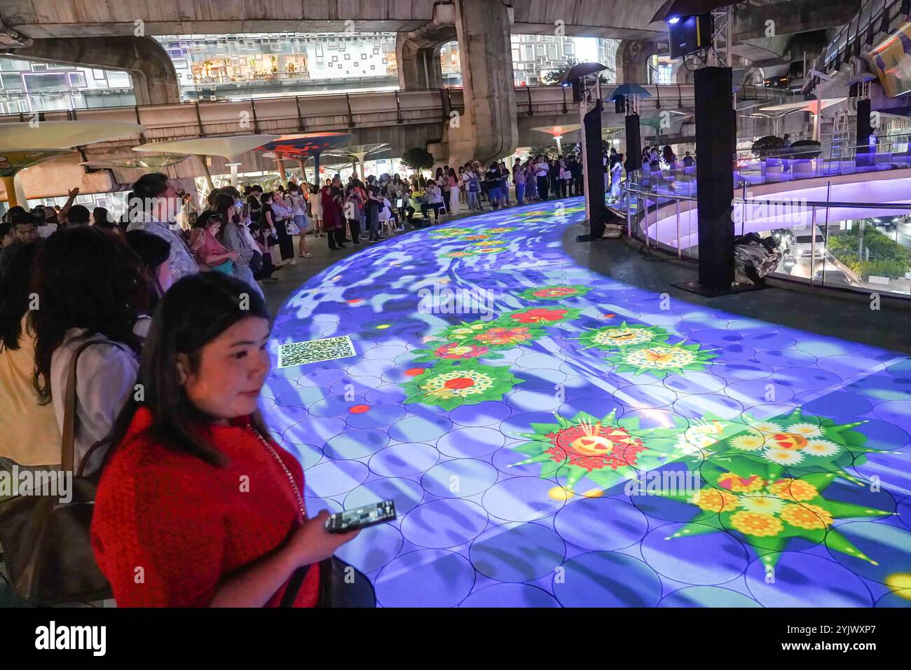 Bangkok, Thailand. November 2024. Während des Festivals besuchen die Menschen die umweltfreundlichen digitalen Krathongs, oder schwimmenden Körbe, auf einer Projektionskarte Fluss der Bangkok Metropolitan Authority (BMA) am Pathumwan Skywalk. Das Digital Loy Krathong Festival zeigt das digitale krathong, das durch Projektionskarten im Einkaufszentrum von Bangkok schwimmt. Quelle: SOPA Images Limited/Alamy Live News Stockfoto