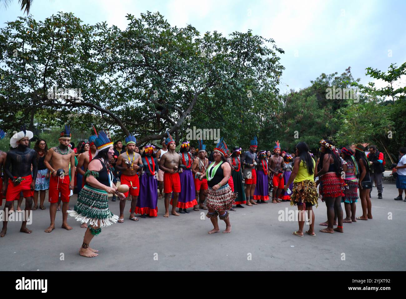 Die Guajajara tanzen traditionelle Tänze während des Wyrau'haw-Rituals im indigenen Dorf Maracan„ in Rio de Janeiro. Unter den Ureinwohnern der Guajajara ist die Wyrau'haw-Feier ein Ritus der Weiblichkeit, der Jugendlichen Mädchen zum Zeitpunkt ihrer ersten Menstruation gewidmet ist. Das indigene Dorf Maracan„ liegt in Brasilien, neben dem berühmten Maracan-„-Fußballstadion von Rio de Janeiro, was das Land für Immobilienentwickler attraktiv macht. Eine Gruppe indigener Aktivisten, die sich 2006 dort niedergelassen haben, kämpft für den Erhalt und die Verteidigung dieses Territoriums. Auf dem Asphalt, zwischen den Gebäuden, t Stockfoto