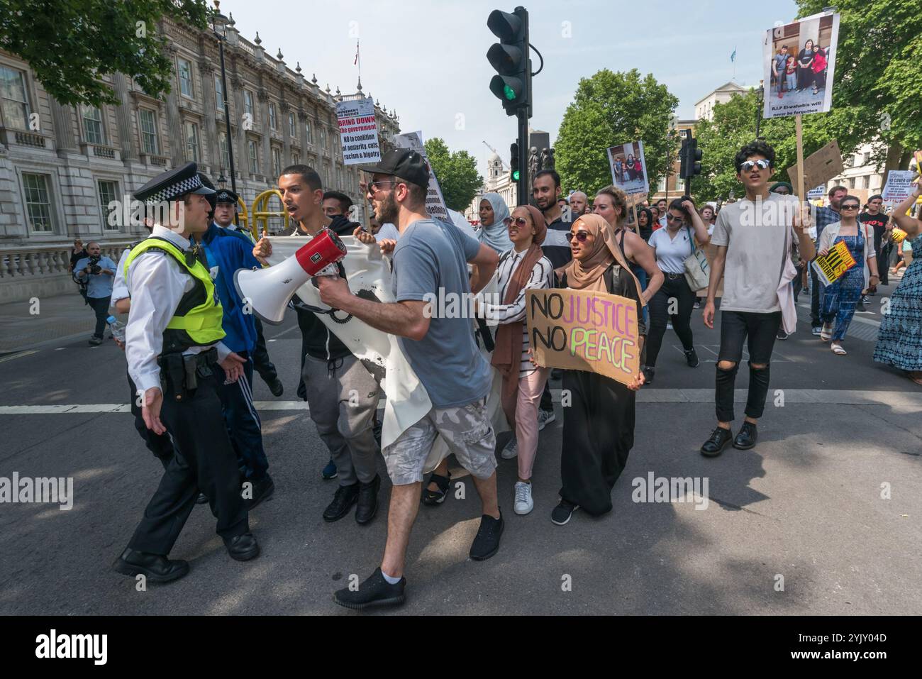 London, Großbritannien. Juni 2017. Als der marsch die Downing Street erreichte, stürzte eine kleine Gruppe auf die Polizeilinie vor den Toren zu. Andere Demonstranten zogen sie zurück und einige der Organisatoren des marsches bildeten eine Linie zwischen Demonstranten und Polizei, die die Demonstranten dazu drängten, einen zu bewegen. Sie hielten dann eine kurze Kundgebung mitten in Whitehall ab, bevor ein Konsens beschloss, zum Parliament Square zu übergehen, wo der marsch mitten auf der Straße endete. Dort gab es weitere Reden und Chöre, während die Demonstranten die Anfragen der Polizei ignorierten, die Straße zu räumen. Nach etwa 20 Minuten zogen die meisten Demonstranten einen Stockfoto