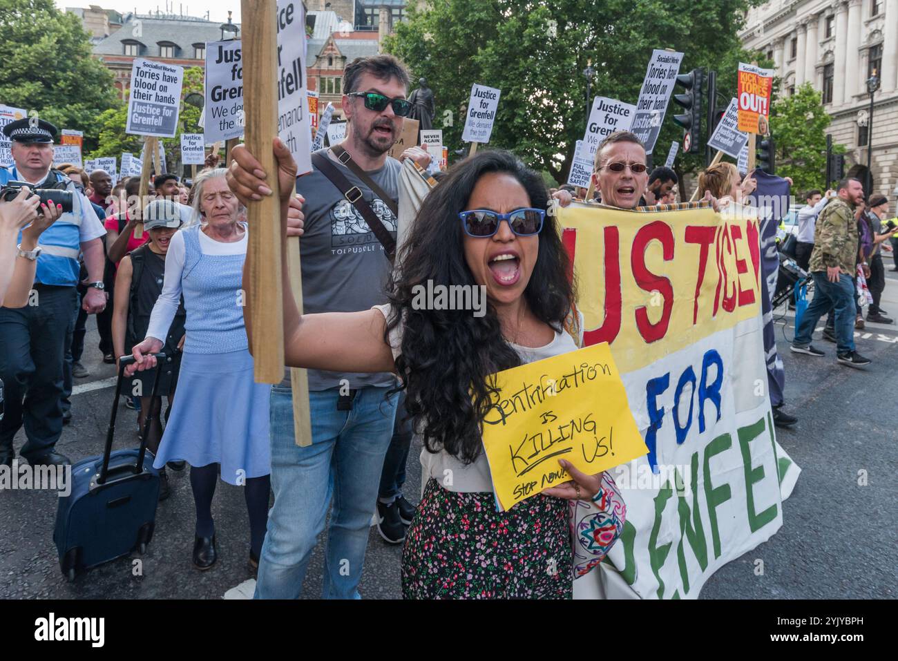 London, Großbritannien. Juni 2017. Mehr als tausend Demonstranten marschierten zur Downing St und drängten an der Polizei vorbei, die versuchte, sie auf den Pflaster gegenüber zu bringen, hielt eine laute Kundgebung vor den Toren ab, bei der Sprecher aus der North Kensington Community Aktivisten, Bewohner anderer Turmblöcke untergebracht und Rassismus entgegengesetzt wurden. Sie riefen zum Rücktritt von Theresa May und ihrem Helfer Gavin Barwell auf, der als Wohnungsminister die nach der letzten Londoner Turmblockbrandkatastrophe empfohlenen Änderungen nicht umgesetzt hatte. Nach einer Kundgebung ging es dort zu weiteren Protesten auf der Stockfoto