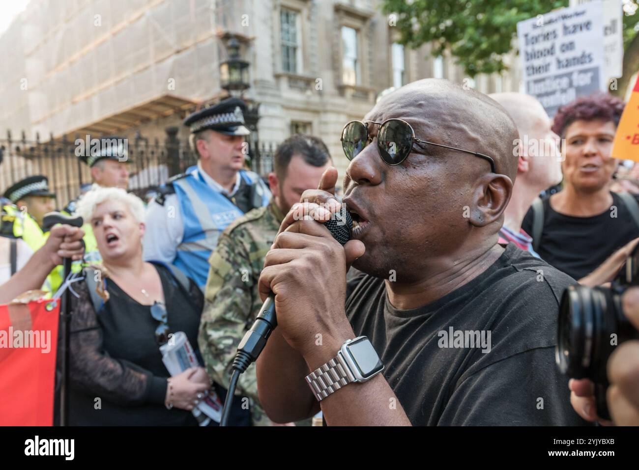 London, Großbritannien. Juni 2017. Demonstranten halten eine laute Kundgebung vor den Toren der Downing Street ab und blockieren Whitehall. Es gab Sprecher aus der North Kensington Community, die Aktivisten, Bewohner von anderen Turmblöcken, die SWP und stehen gegen Rassismus. Sie riefen zum Rücktritt von Theresa May und ihrem Helfer Gavin Barwell auf, der als Wohnungsminister die nach der letzten Londoner Turmblockbrandkatastrophe empfohlenen Änderungen nicht umgesetzt hatte. Nach einer Kundgebung zogen sie dort auf, um zu weiteren Protesten bei der BBC und anderswo zu marschieren. Stockfoto