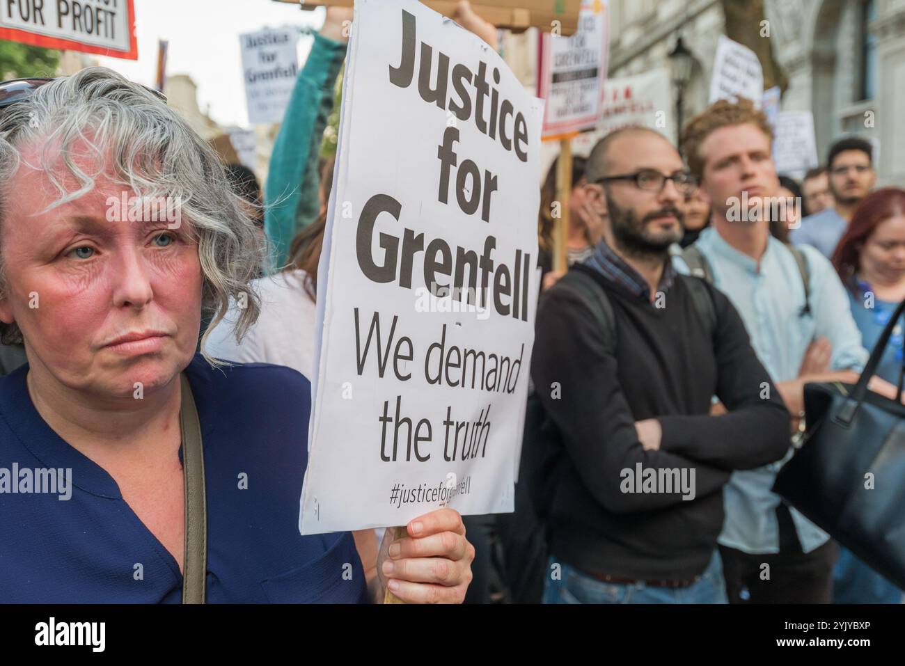 London, Großbritannien. Juni 2017. Demonstranten bei einer lauten Kundgebung vor den Toren der Downing Street, die Whitehall blockierte. Es gab Sprecher aus der North Kensington Community, die Aktivisten, Bewohner von anderen Turmblöcken, die SWP und stehen gegen Rassismus. Sie riefen zum Rücktritt von Theresa May und ihrem Helfer Gavin Barwell auf, der als Wohnungsminister die nach der letzten Londoner Turmblockbrandkatastrophe empfohlenen Änderungen nicht umgesetzt hatte. Nach einer Kundgebung zogen sie dort auf, um zu weiteren Protesten bei der BBC und anderswo zu marschieren. Stockfoto