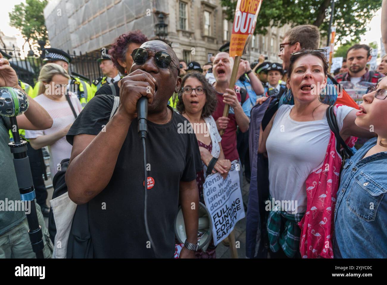 London, Großbritannien. Juni 2017. Demonstranten halten eine laute Kundgebung vor den Toren der Downing Street ab und blockieren Whitehall. Es gab Sprecher aus der North Kensington Community, die Aktivisten, Bewohner von anderen Turmblöcken, die SWP und stehen gegen Rassismus. Sie riefen zum Rücktritt von Theresa May und ihrem Helfer Gavin Barwell auf, der als Wohnungsminister die nach der letzten Londoner Turmblockbrandkatastrophe empfohlenen Änderungen nicht umgesetzt hatte. Nach einer Kundgebung zogen sie dort auf, um zu weiteren Protesten bei der BBC und anderswo zu marschieren. Stockfoto