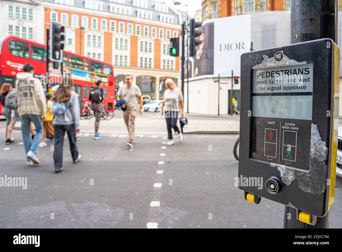 Taste und grünes Signal aktivieren, um Fußgängern auf der Spur Platz zu geben, London.UK. Stockfoto