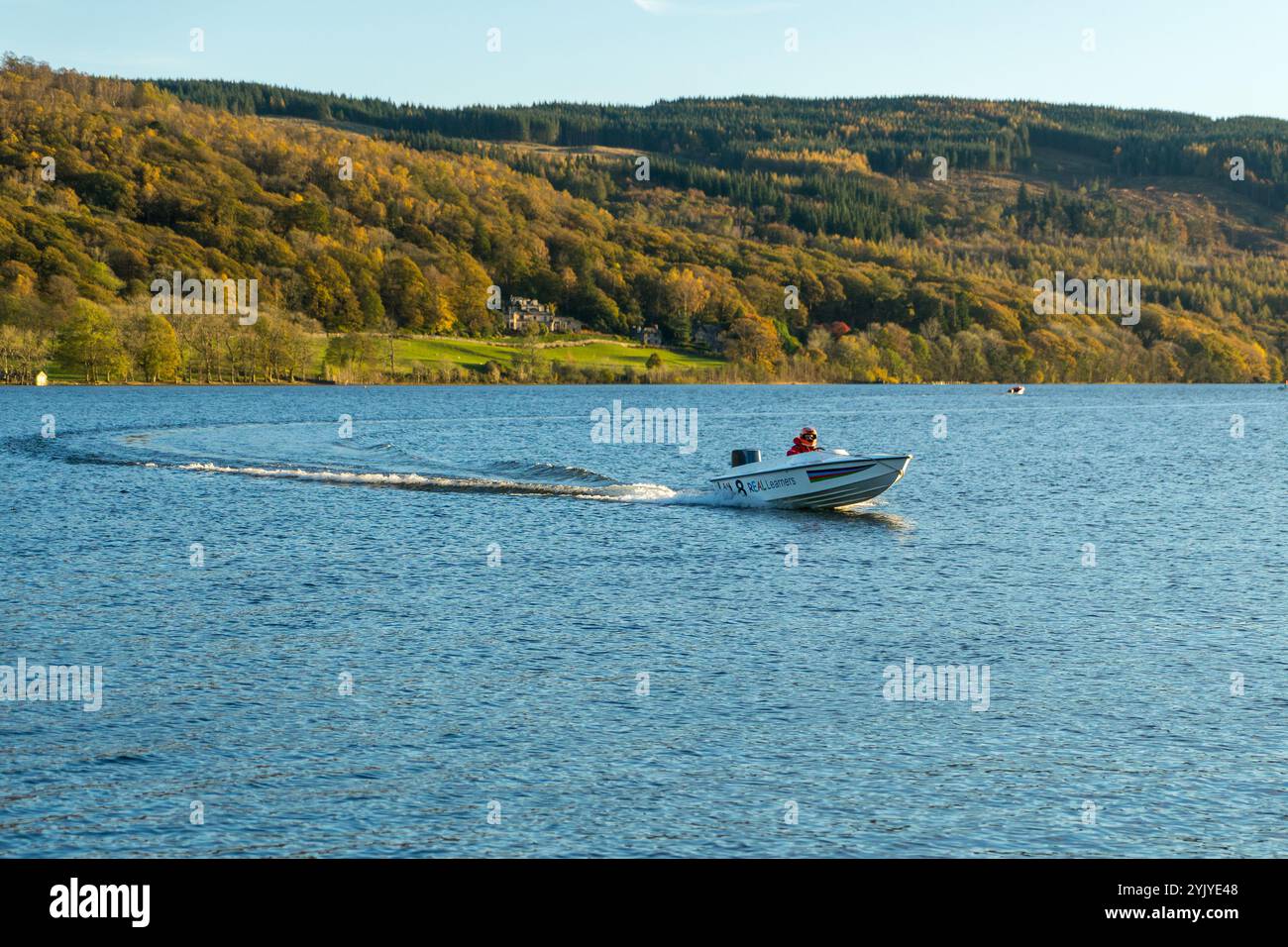 Ein Motorboot auf Coniston Water mit seinem Bug in der Luft gleitet an einem hellen Herbsttag A während der Coniston Power Boat Records Woche über den See. Stockfoto