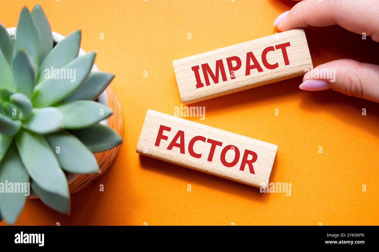 Symbol für Aufprallfaktor. Holzblöcke mit den Worten Impact Factor. Schöner oranger Hintergrund mit saftiger Pflanze. Geschäftsmann Hand. Business und Impact Stockfoto