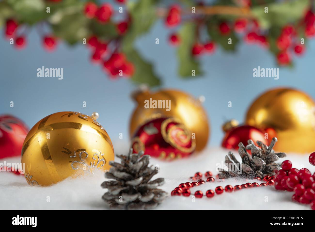 Weihnachtsdekoration mit goldenen und roten Kugeln auf Schneeeffekt Stockfoto