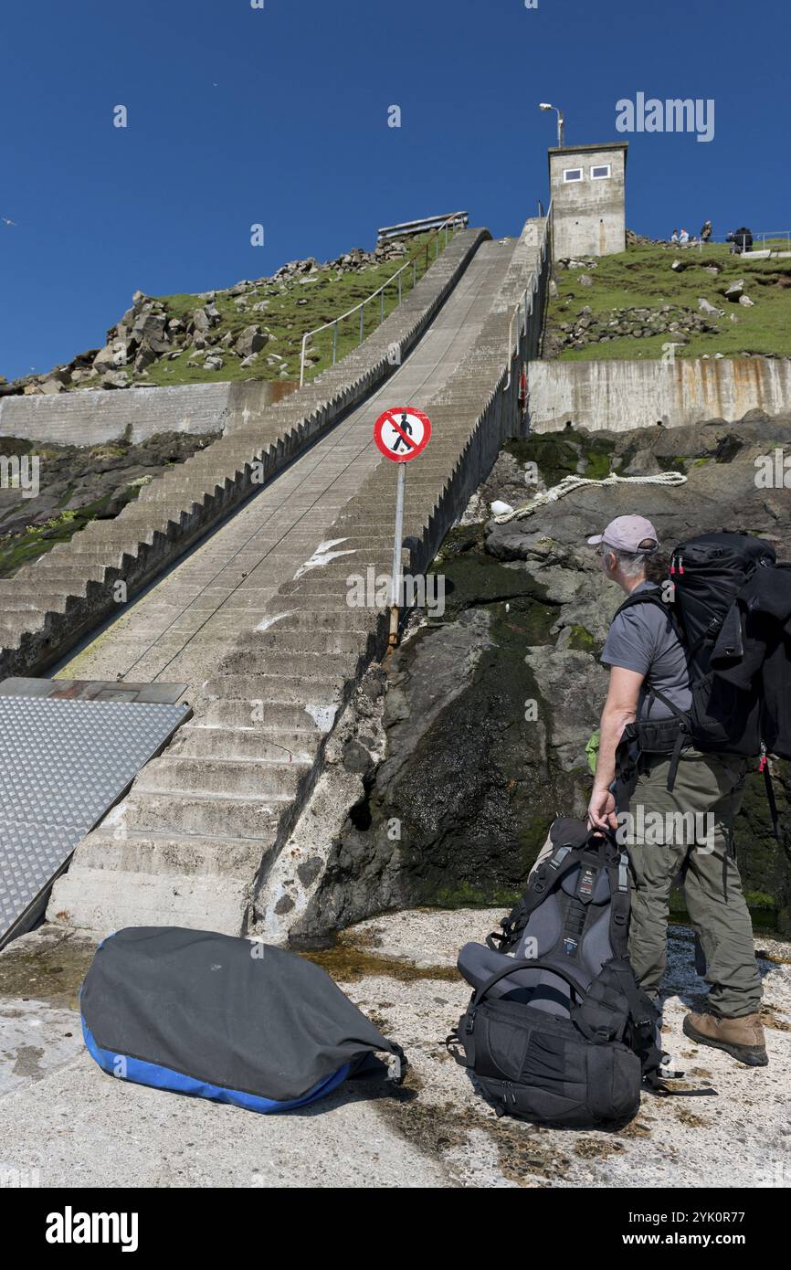 Hafen, Bootsanlegestelle, Treppen mit Lastenaufzug mit Stahlseil und Seilwinde, Touristen mit Gepäck, Mykines, Utoyggjar, Färöer Inseln, D Stockfoto