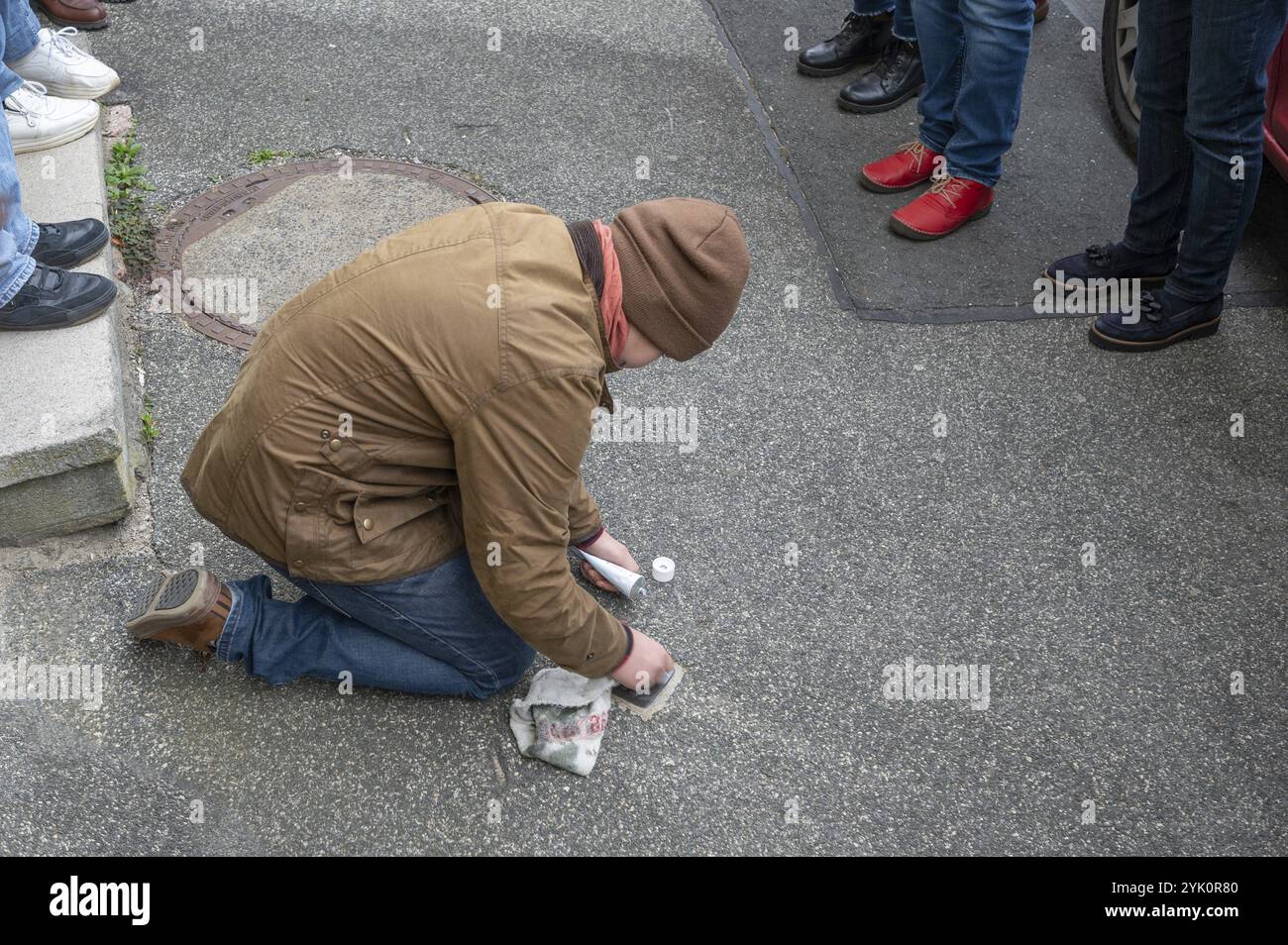 Pupille poliert und reinigt einen Stolperstein zur Erinnerung an die Nacht des Broken Glass am 9. November 1938, Stolperstein Tour in Schnaittach, Mitte F Stockfoto