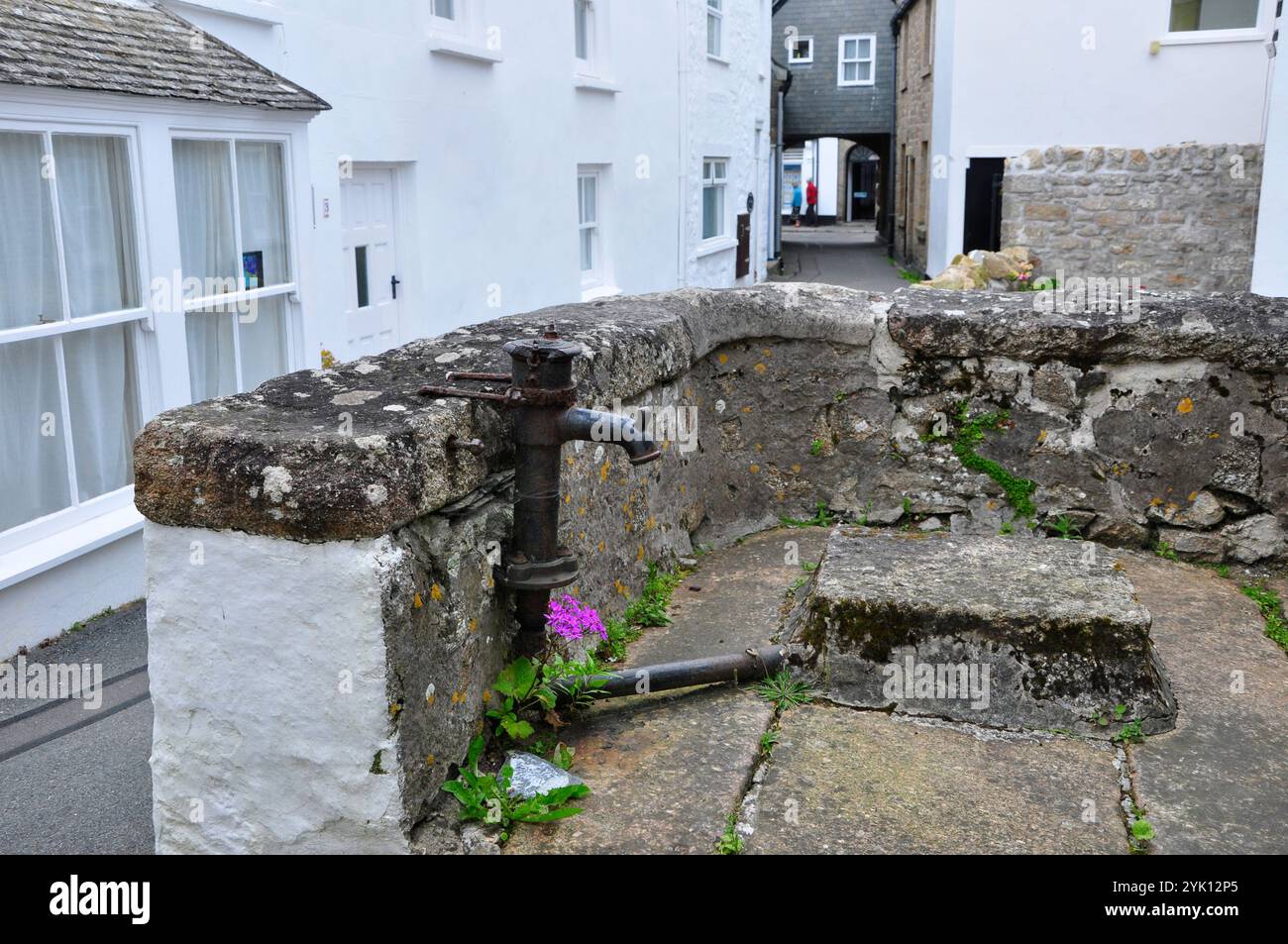 Alte gusseiserne Süßwasserpumpe im kleinen Hof eines Landhauses im Zentrum von Hugh Town auf der Insel St. Marys auf den Scilly-Inseln Stockfoto