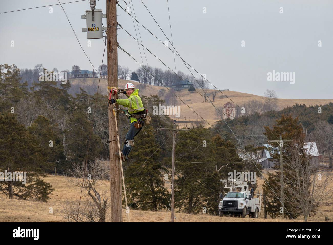 Vertrag Störungssucher Brandon Sims kletterte Gebrauchspfosten für zukünftige stehen Kabel am Rahmen als Virginia's BARC Electric Cooperative die Art und Weise, in der Lexington, Virginia Bereich Installation der Glasfaserkabel an das vorhandene Stromnetz, die zuverlässig mit hoher Geschwindigkeit auf den Bereich zum ersten Mal bringen führt. Die ländlichen Gebiete, wo geschäftliche und private Verbraucher Breitbanddienst sind wahrscheinlicher, höhere Einkommen, niedrigeren Arbeitslosenquoten und ein stärkeres Wachstum als die ohne Breitbandanschluss zu genießen. Da Breitband bietet den ländlichen Gebieten Konnektivität, Wirtschaft, Bildung, Gesundheitsversorgung und anderen Servic Stockfoto