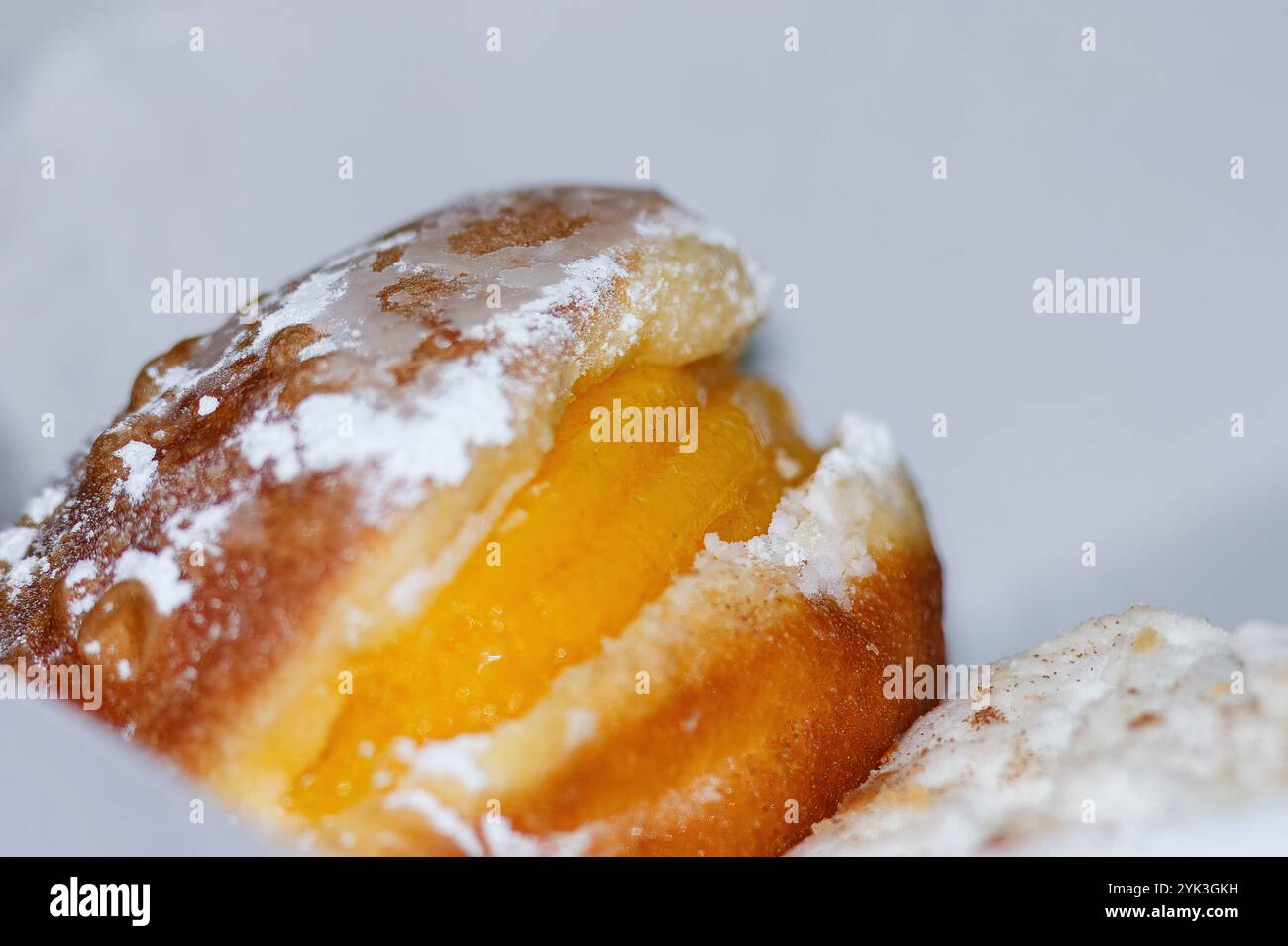 Berliner Ball. Es ist ein Mehlsüß in Form einer gebratenen Kugel, der dann Eigelb süß im Inneren hat, bestreut mit Puderzucker. Stockfoto