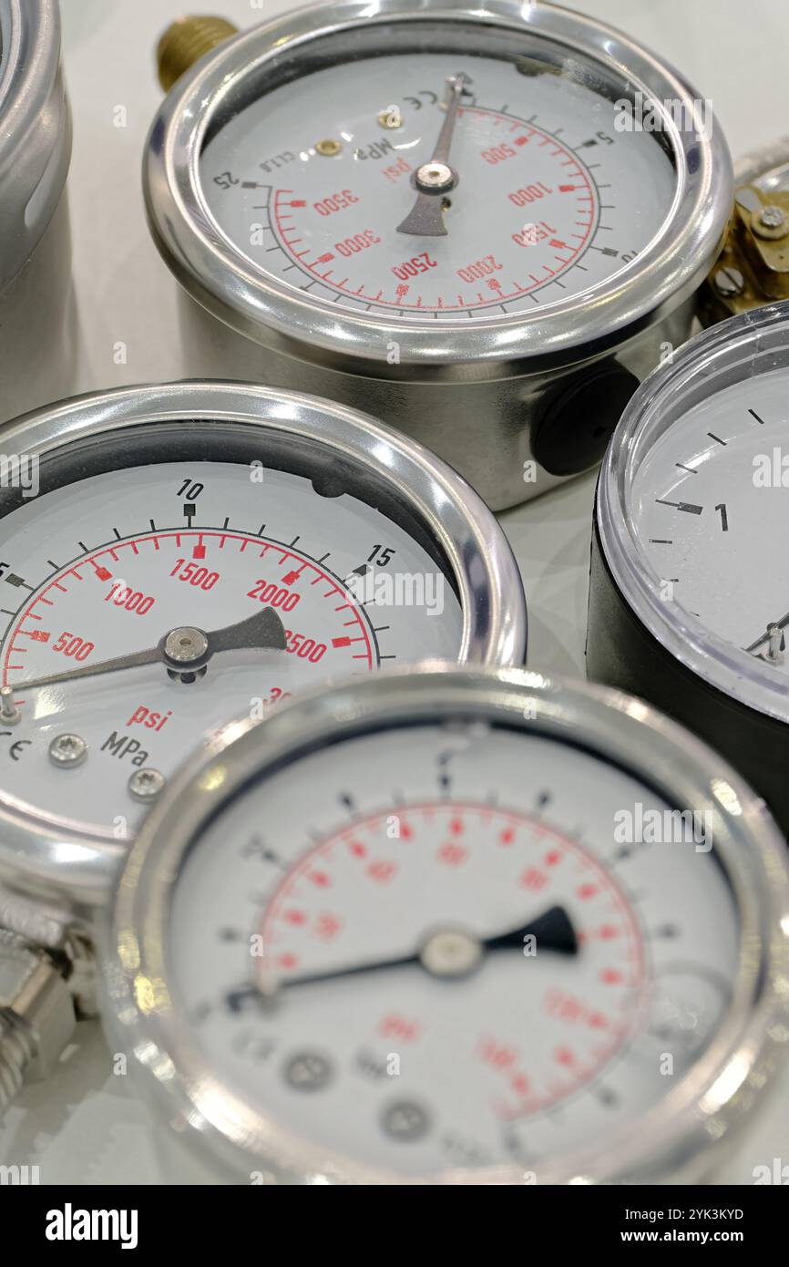 Gruppe mehrerer mechanischer Manometer. Nahaufnahme, selektiver Fokus, abstrakter Technologiehintergrund. Stockfoto