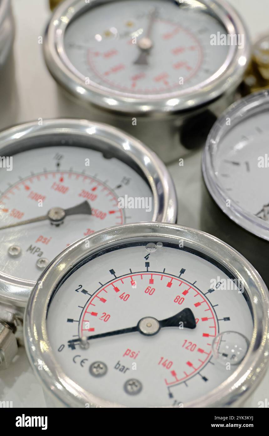 Gruppe mehrerer mechanischer Manometer. Nahaufnahme, selektiver Fokus, abstrakter Technologiehintergrund. Stockfoto