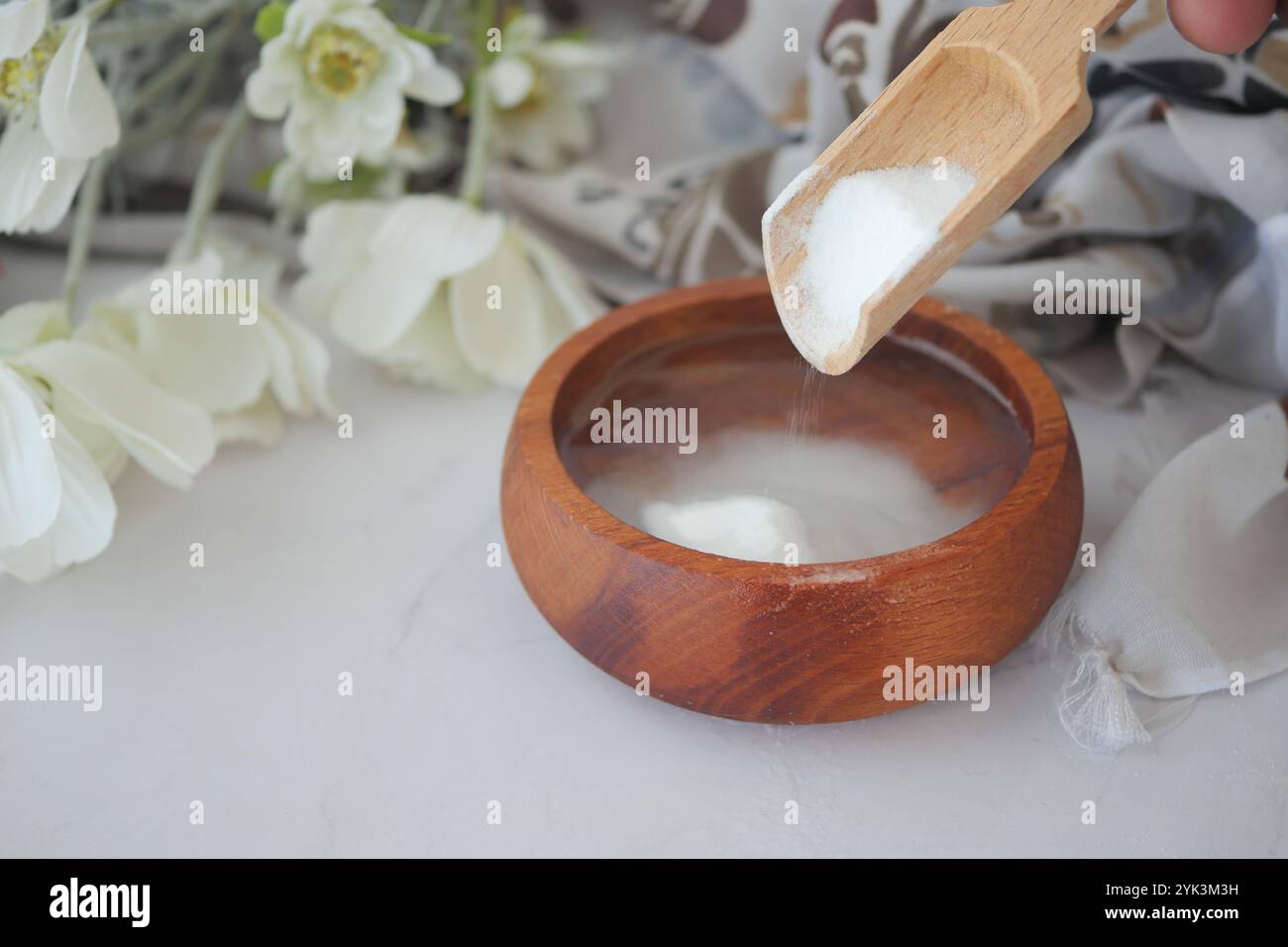 Gießen Sie Backpulver in eine Wasserschüssel Stockfoto
