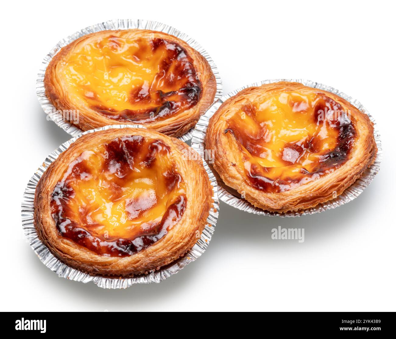 Pastell de nata Torten in Folientassen auf weißem Hintergrund. Datei enthält Beschneidungspfad. Stockfoto