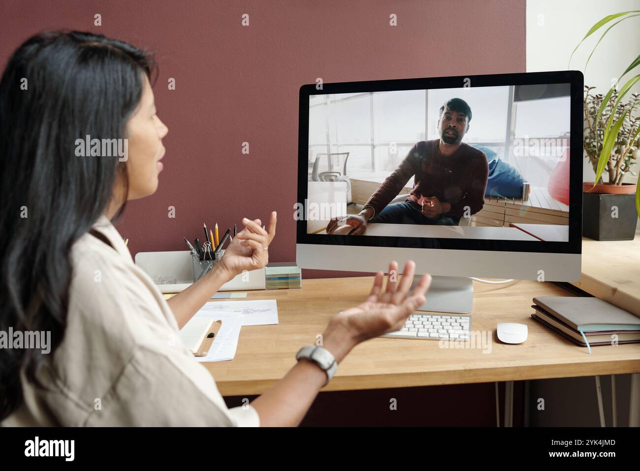 Selbstbewusster Lehrer der modernen Sprachschule, der männlichen Schülern während des Online-Unterrichts Regeln auf dem Computerbildschirm erklärt Stockfoto