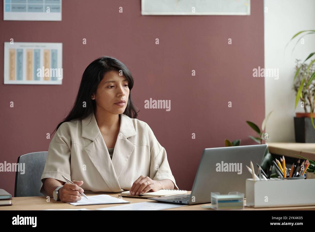 Junger ernsthafter Lehrer, der auf den Laptop-Bildschirm schaut, während er sich ein Online-Video über eine neue Sprachschule oder einen neuen Kurs ansieht Stockfoto