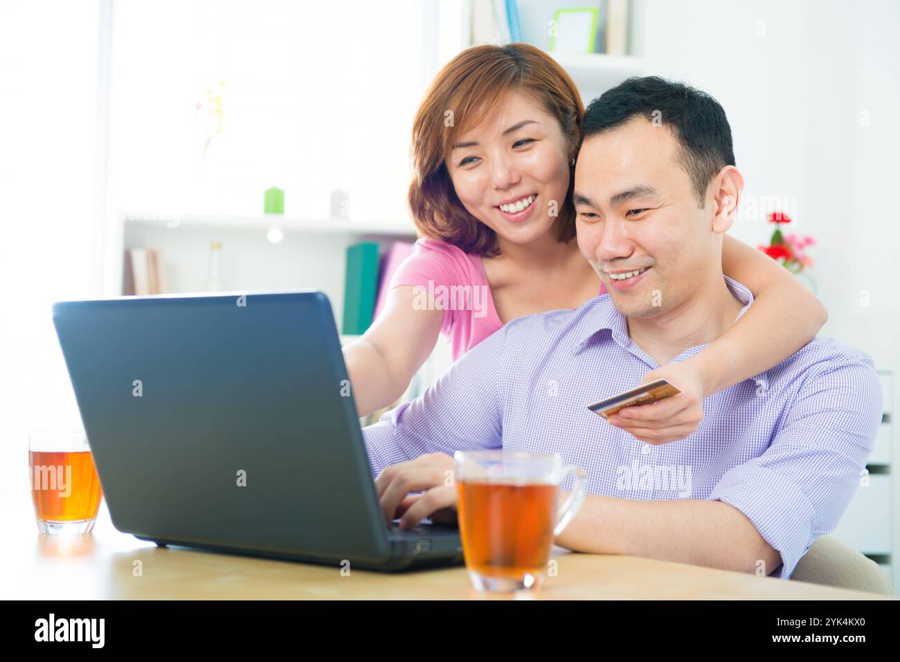 Online-Shopping Glückliches asiatisches Paar, das online mit Kreditkarte und Computer zu Hause einkaufen Copyright: xZoonar.com/szefeix 1053985071st Stockfoto