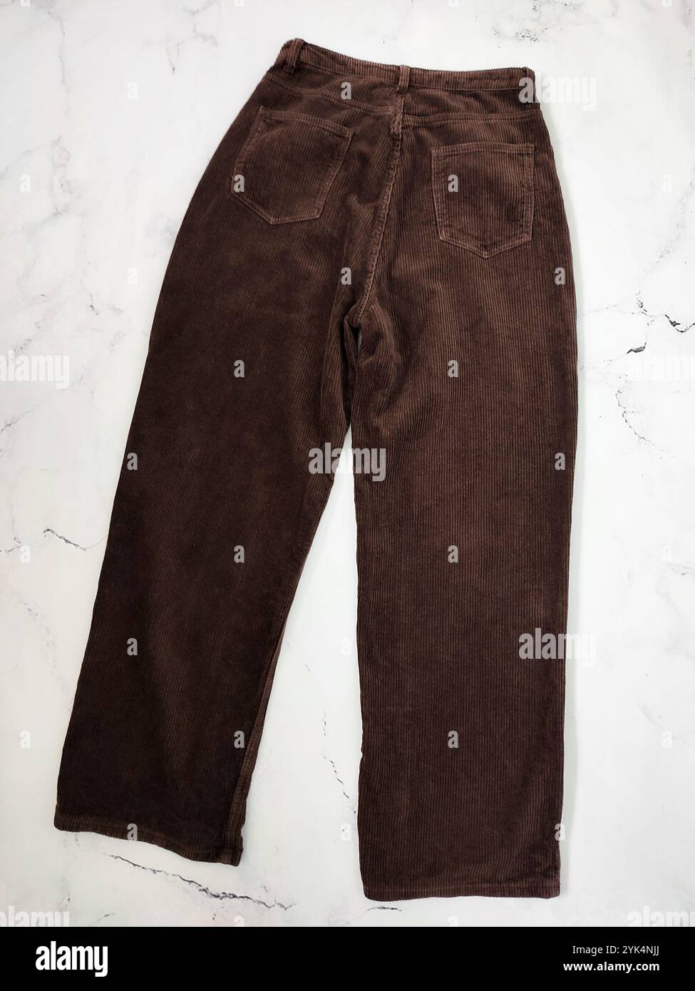 Braune Cordhosen Rückseite flach liegen am weißen Marmorhintergrund Draufsicht, Kleidung, Stoff, Bekleidungsgeschäft, Nähen, Herstellung, Textil, Gewebe Stockfoto