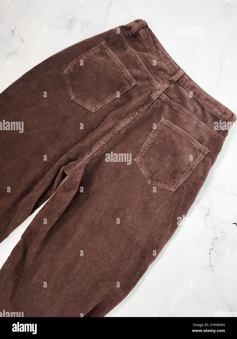 Braune Cordhosen Rückseite flach liegen am weißen Marmorhintergrund Draufsicht, Kleidung, Stoff, Bekleidungsgeschäft, Nähen, Herstellung, Textil, Gewebe Stockfoto
