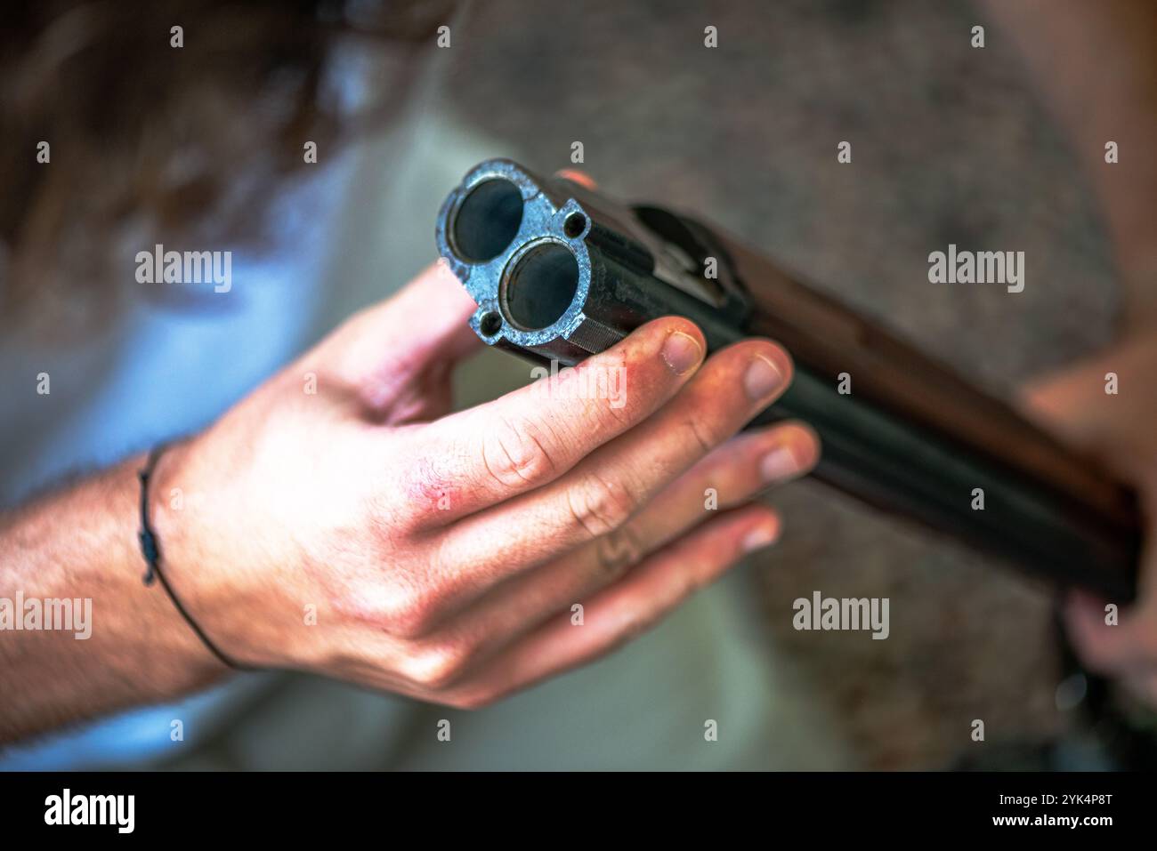 Ein Mann reinigt ein altes Gewehr sorgfältig mit Öl und Reinigungsgeräten und zeigt die Liebe zum Detail und die Handwerkskunst alter Schusswaffen. Stockfoto