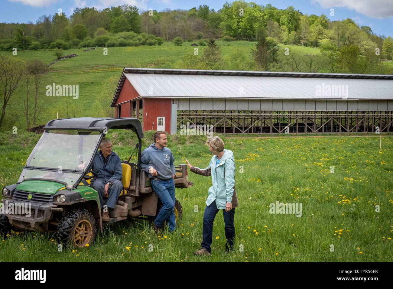 Clark Farms Creamery ist eine generationenübergreifende Milchfarm in Delhi, New York. Hier spricht Barbara Robertson (R), FSA-Programmtechnikerin für Delaware/Sullivan County, mit Kyle Clark (2. R), der neuesten Generation, während Großvater Pete zusieht. (USDA/FPAC Foto von Preston Keres) Stockfoto