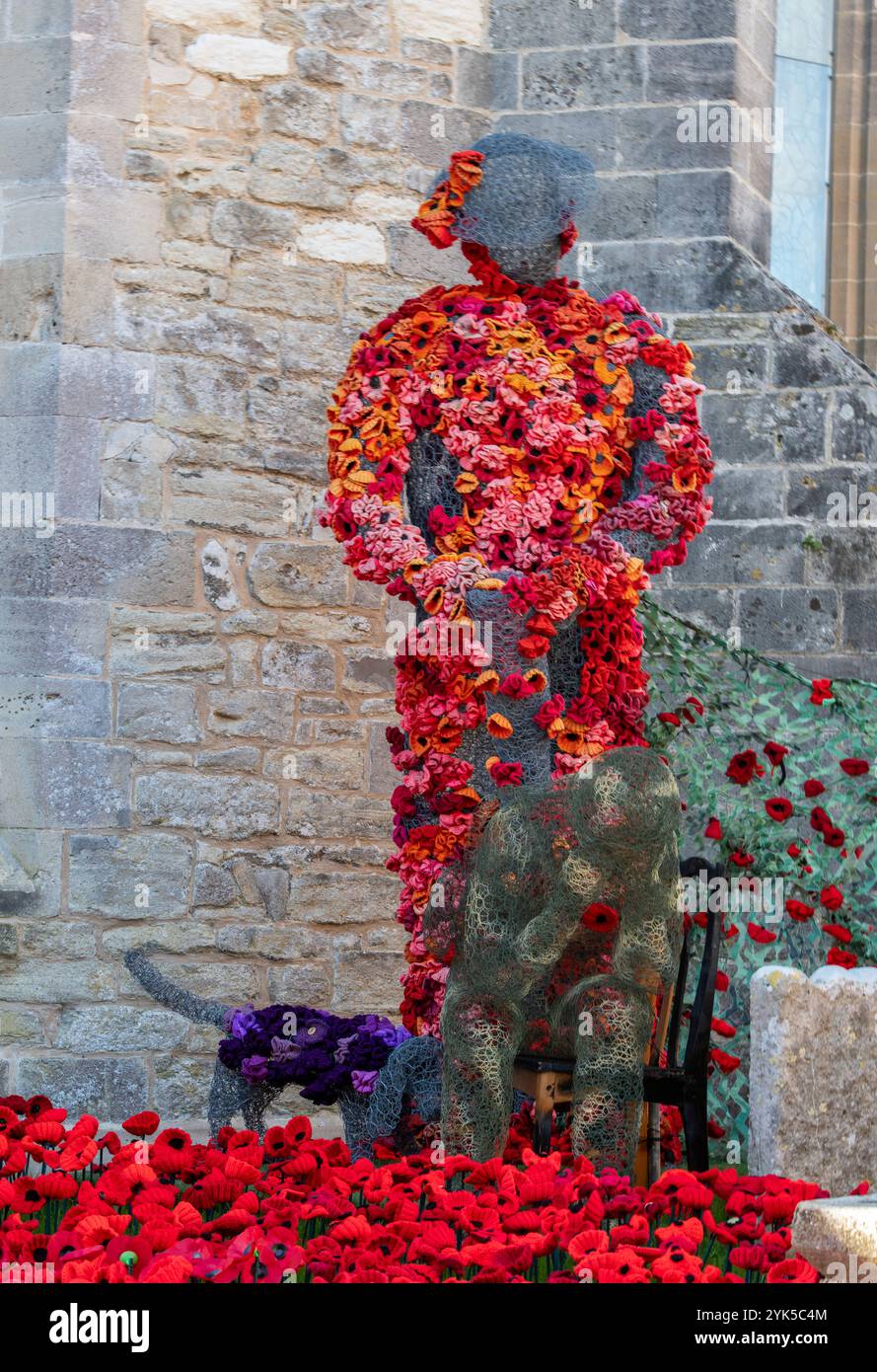 Soldatenfigur aus hellrotem Mohn in einem Gedenkgarten in Lymington, Hampshire, Großbritannien Stockfoto