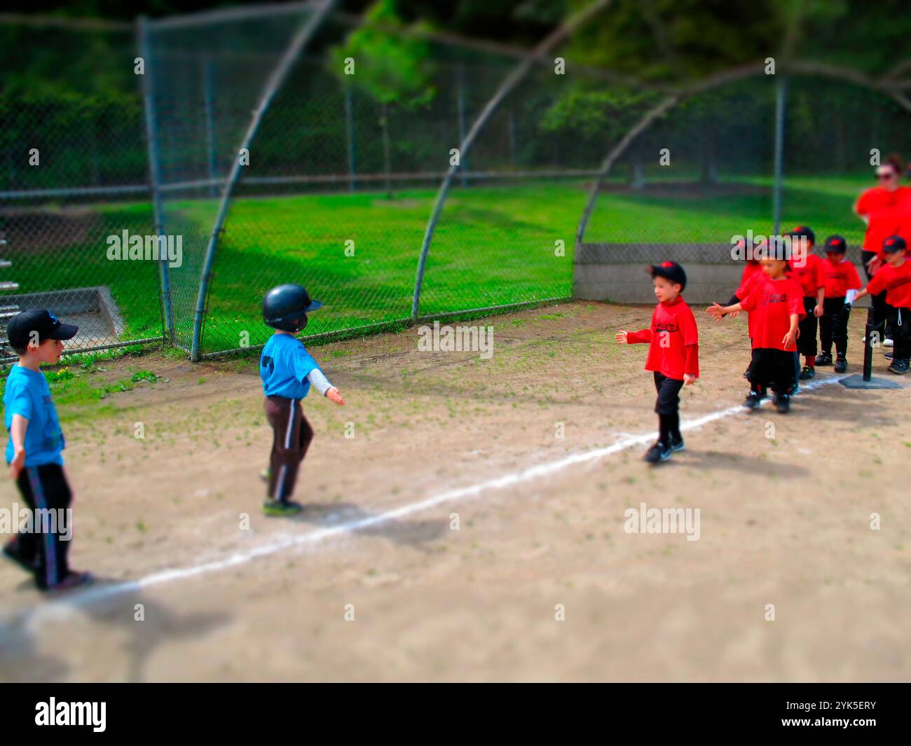 Kinder schütteln sich nach dem Abschlagball-Spiel die Hand. Stockfoto