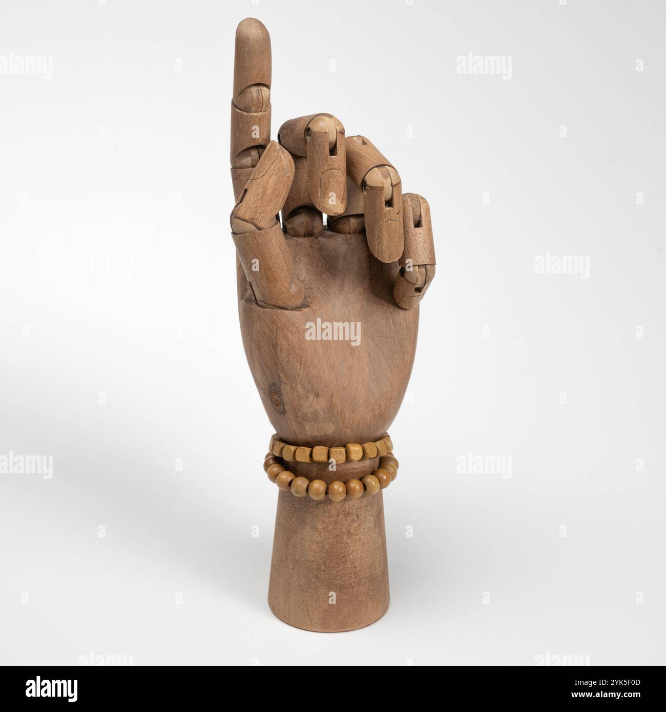 Hölzerne Hand mit zwei hölzernen Armbändern auf weißem Hintergrund Stockfoto