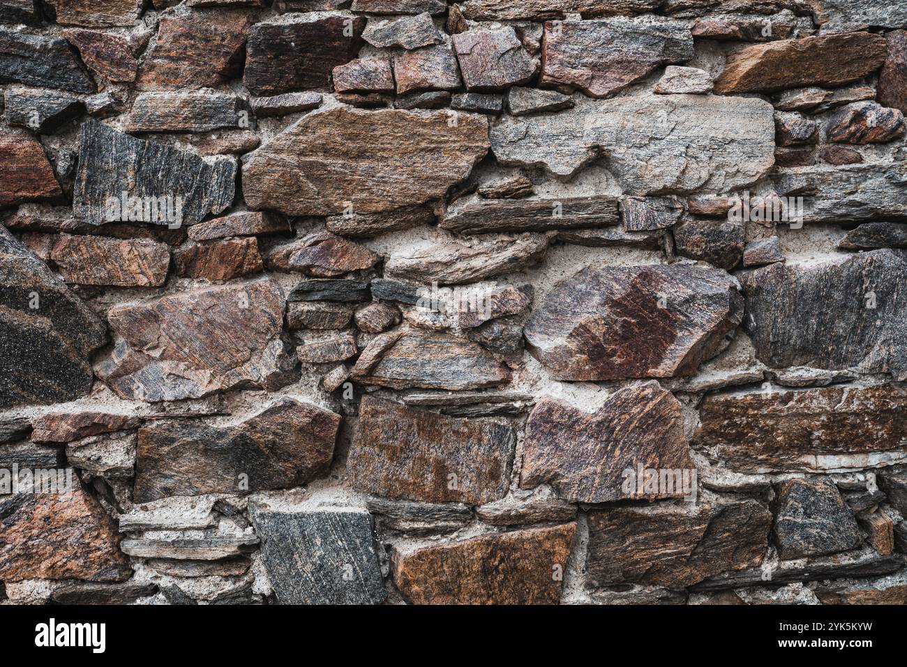 Alte Steinmauer bei den Burgruinen. Konsistenz der verwitterten mittelalterlichen Steinmauer Stockfoto