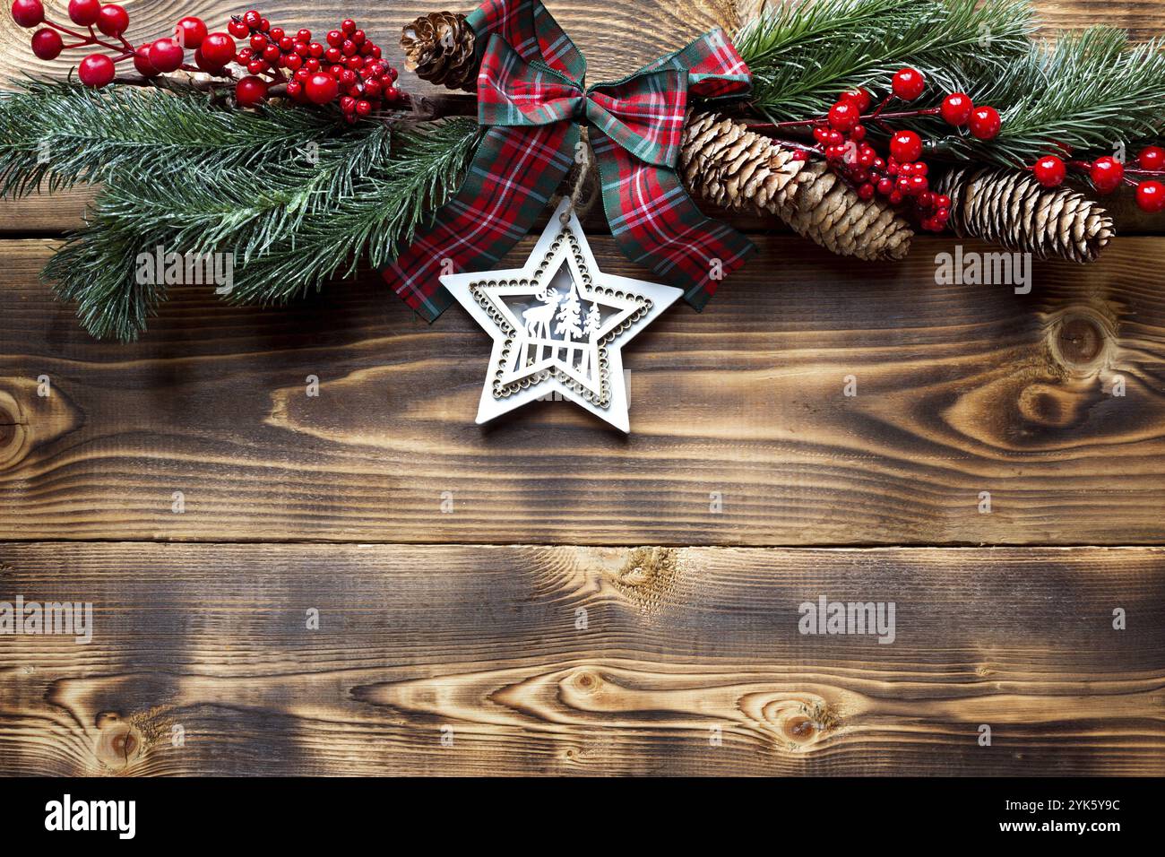 Weihnachtsdekor mit Holzhintergrund. Neujahr, Weihnachtsstimmung, grüne Fichtenäste, Dekoration: Sterne, Geschenkbox, weihnachtsbaum, Schneeflocken, Zapfen Stockfoto