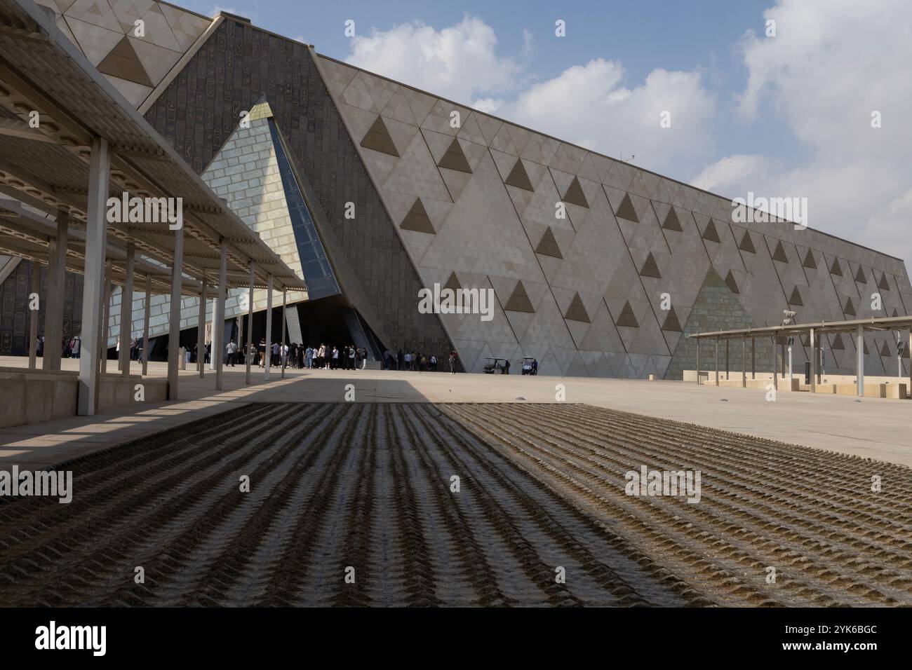 Wasser tröpfelt über Pyramidensteine in einem flachen Becken auf der Esplanade vor dem Großen Ägyptischen Museum (GEM) nach seiner Eröffnung am 16.10.24. Stockfoto