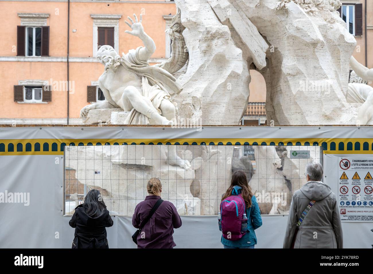 Rom, Italien - 14. November 2024: Besucher beobachten Fontana dei Quattro Fiumi auf dem Navona-Platz während der Renovierungsarbeiten zum Jubiläum 2025 über Barrieren Stockfoto