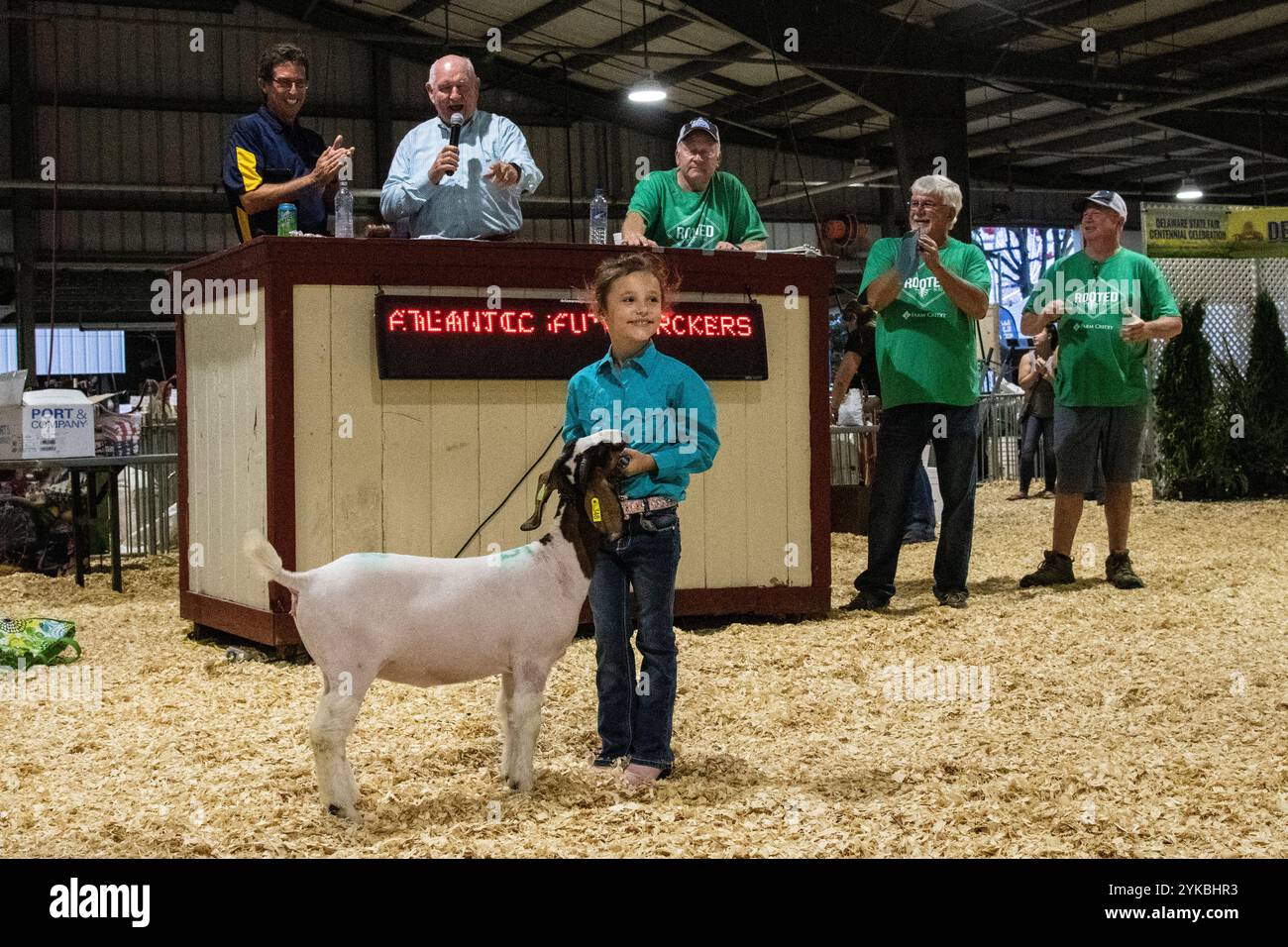 Sonny Perdue, Sekretär des US-Landwirtschaftsministeriums (USDA), spricht über die Zukunft der Landwirtschaft, während Adalyn Lyon auf der Delaware State Fair am 25. Juli 2019 in Harrington, DE, ihre Ziege den Bietern zeigt. Minister Perdue und seine Frau Mary Perdue gehen zusammen mit dem Landwirtschaftsminister Michael Scuse auf die Messe, der ihnen FFA & 4-H Exponate zeigte, durch die Viehscheune ging, zusammen mit dem Gouverneur John Carney von Delaware an der Kennzeichenzeichnung teilnahm und am 25. Juli 2019 am Governor’s Day Dinner in Harrington, DE, teilnahm. Die Delaware State Fair, Inc Stockfoto