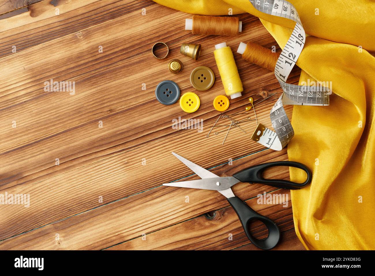 Auf einem Holztisch angeordnete Bastelwerkzeuge und Materialien für Nähprojekte Stockfoto