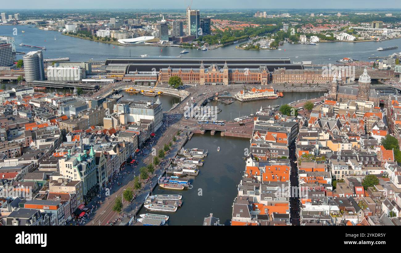 Panoramablick auf den Amsterdamer Hauptbahnhof und die umliegenden Wasserstraßen, die die einzigartige Mischung aus Charme und Moderne der alten Welt einfangen. Stockfoto