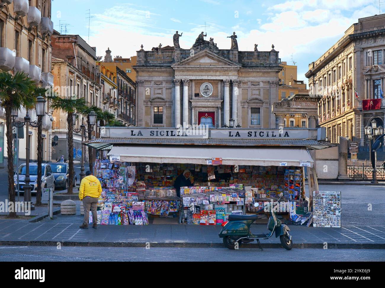 Kiosk auf der Piazza Stesicoro mit Blick auf das römische Amphitheater und die Kirche San Biagio. Eine Vespa steht vor dem Kiosk. Catania, Sizilien. Stockfoto