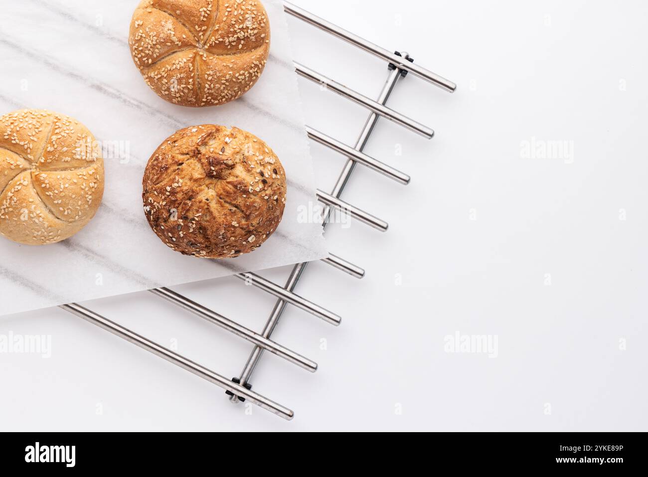 Frisch gebackene Rolls Brotbrötchen auf kühlendem Metallgestell in der Küche über weißem Hintergrund Stockfoto