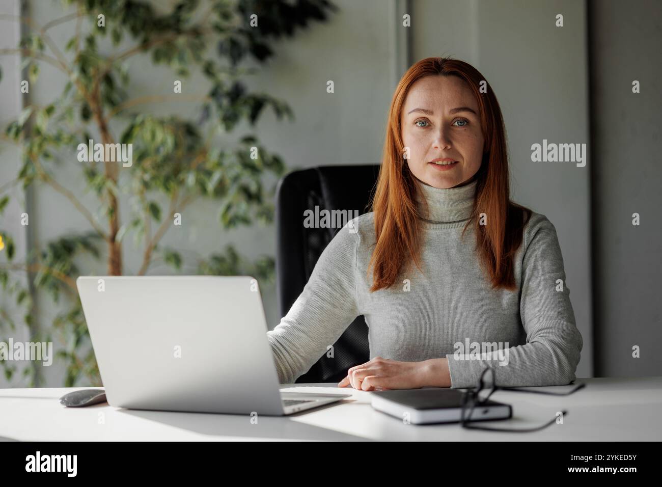 Selbstbewusste und professionelle Frau in einem modernen Büroumfeld, die Führung, Befähigung und Erfolg am Arbeitsplatz demonstriert Stockfoto