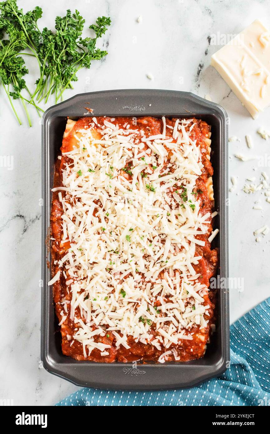 Lasagne-Roll-ups in einer mit Käse belegten Backform Stockfoto