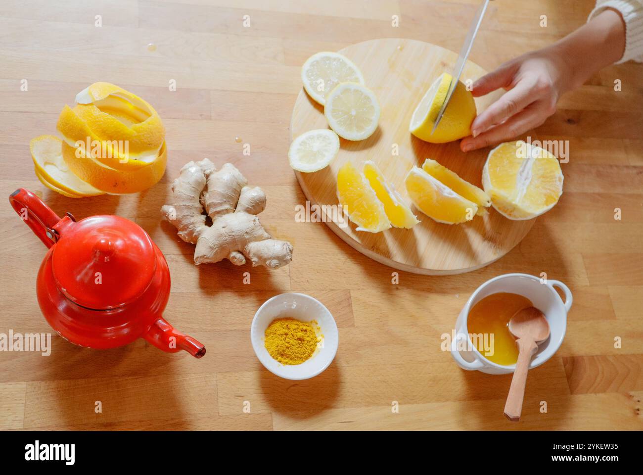 Schneiden Sie mit den Händen Zutaten aus Zitronen, Ingwer, Kurkuma und Honig-Tee Stockfoto