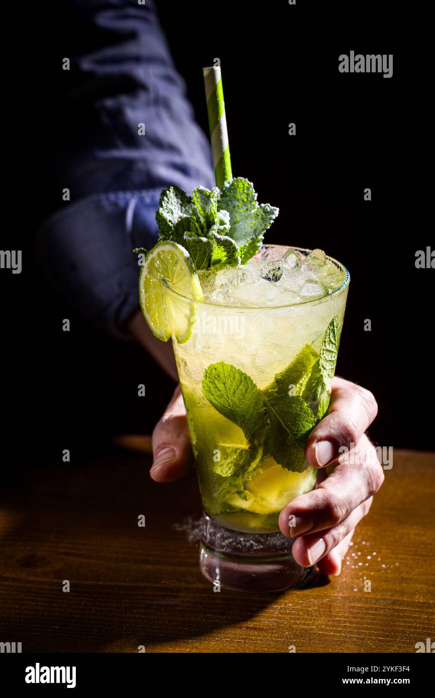 Ein erfrischender Mojito-Cocktail im Glas, garniert mit frischen Limettenscheiben und Minze. Die lebendigen Farben und Textur sorgen für einen Sommer-Vibe. Stockfoto