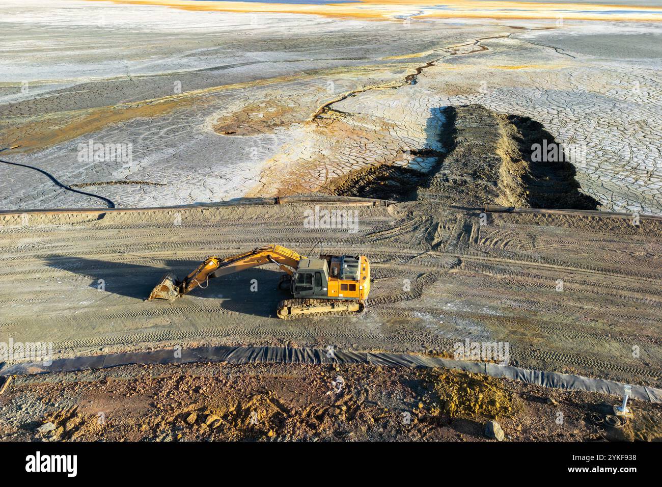 Aus der Vogelperspektive eines großen gelben Baggers, der im Bergbaugebiet Rio Tinto in Huelva, Spanien, in Betrieb ist, mit strukturiertem Boden und lebhaften Mineralablagerungen Stockfoto