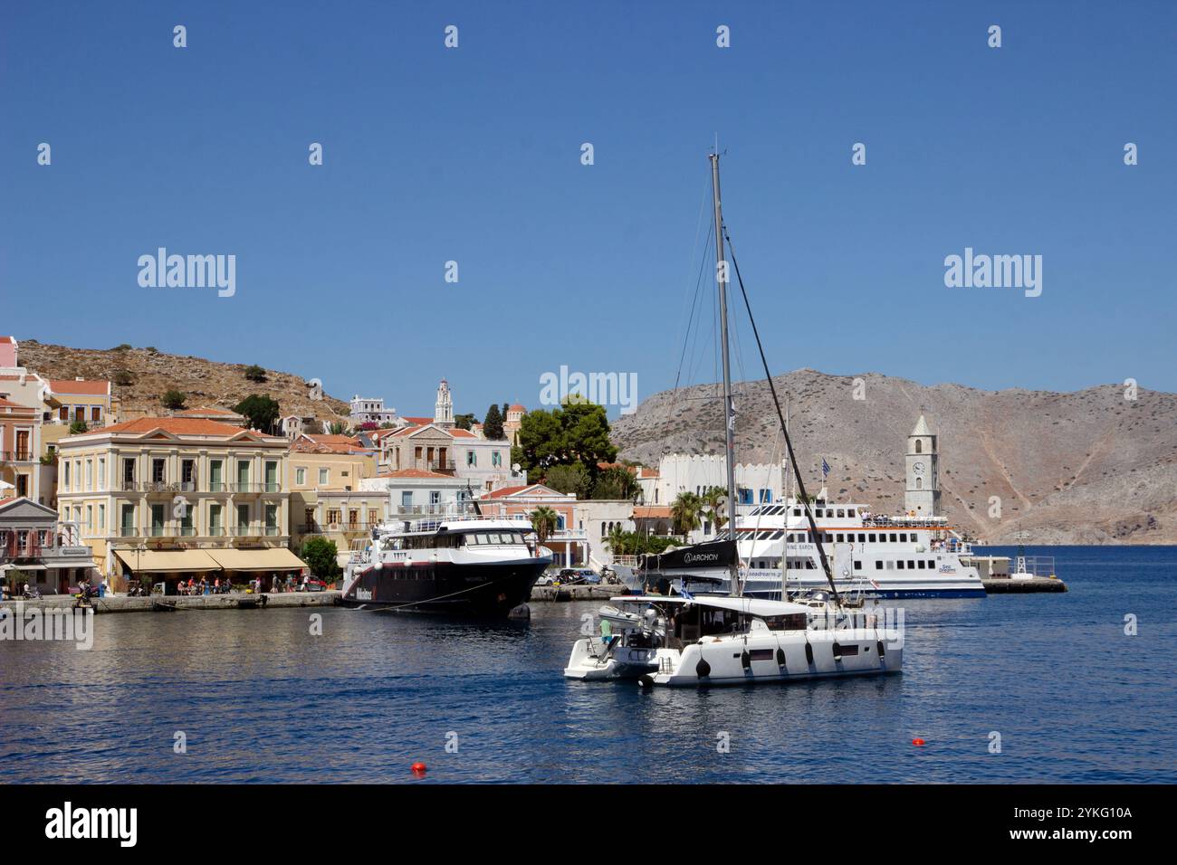 Der Hafen von Symi Stadt auf der griechischen Insel Symi in der dodekanesischen Inselkette mit seinen farbenfrohen Häusern im neoklassizistischen Stil. Stockfoto