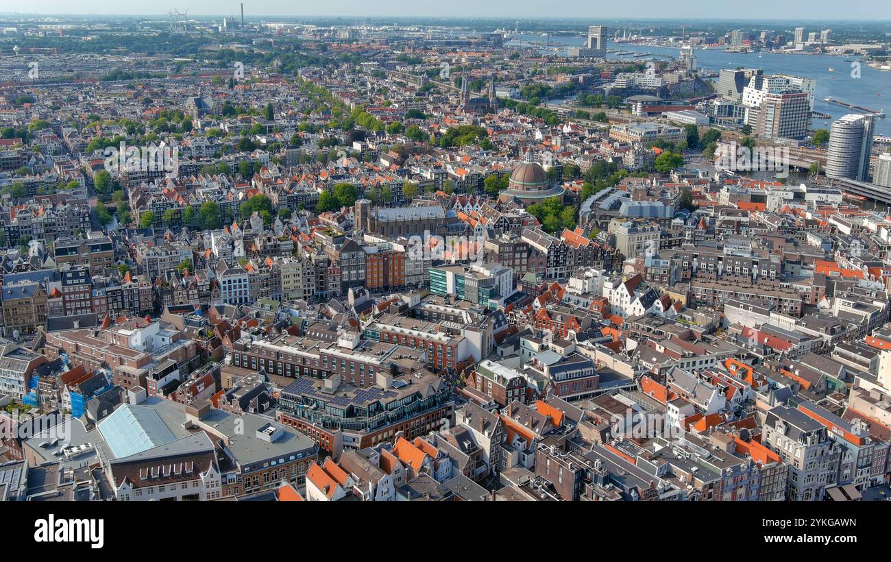 Atemberaubende Aussicht auf Amsterdams historische Stadtlandschaft mit ikonischer holländischer Architektur, leuchtenden roten Dächern und bezaubernden Kanälen aus der Vogelperspektive. Perfekt für Reisen, Stockfoto